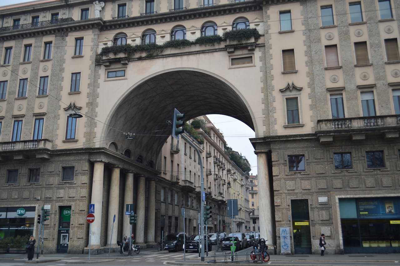 about-us Street view of a historic arched building in Milan, Italy showcasing classic Italian architecture.